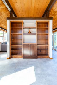 Custom wood built-in with open display shelving and lower media cabinet in a Brookwood home in Fort Wayne, Indiana