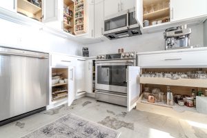 Custom white kitchen cabinetry featuring pull-out shelves, smart storage solutions, and stainless steel appliances in a Brookwood home in Fort Wayne, Indiana