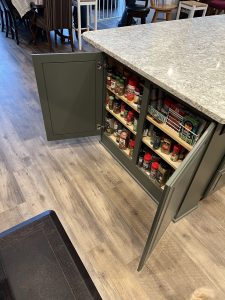 Custom kitchen island featuring pull-out spice racks and smart storage cabinetry in a Brookwood home in Fort Wayne, Indiana