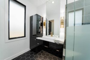 Custom master bathroom with glass shower and modern black-and-white design in a Brookwood home in Fort Wayne, Indiana